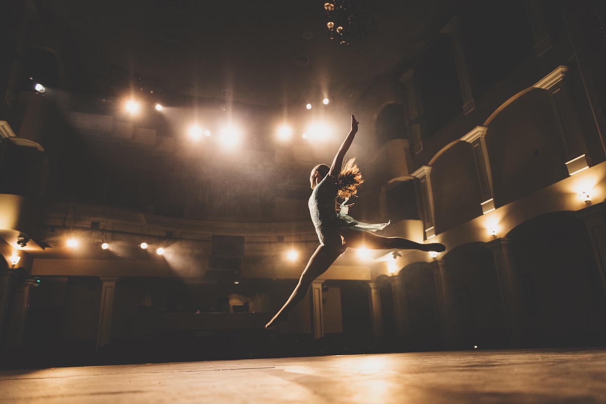 student leads across stage with lights