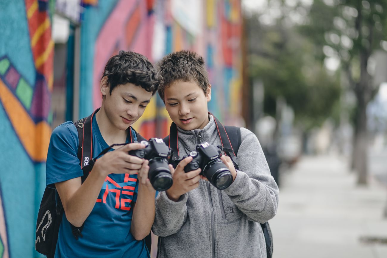 students look into camera together at a photo they took